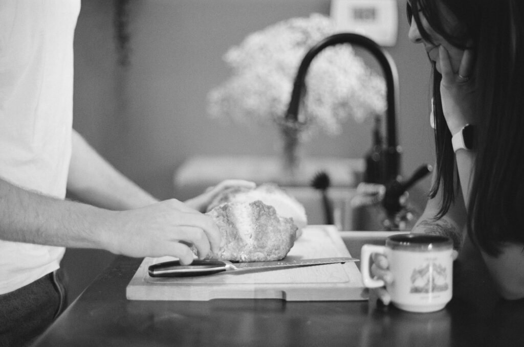 couple slicing bread, at home, shot on film.