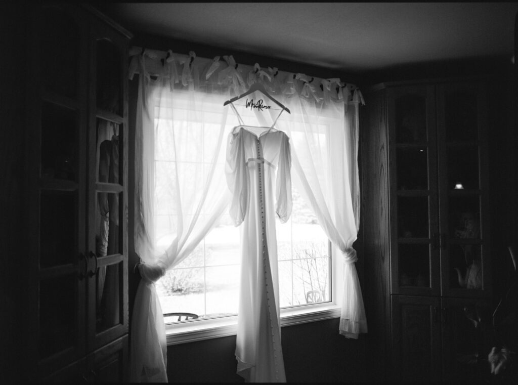 wedding dress hanging in window