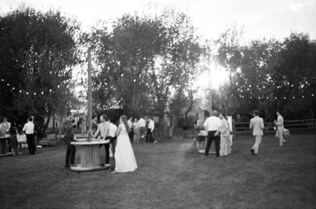 black and white candid photo of guests in backyard wedding