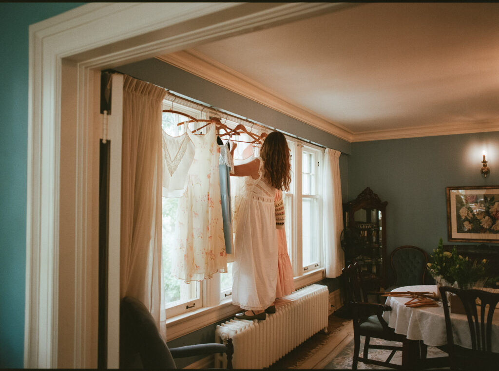 documentary-style photo of bride hanging up dresses