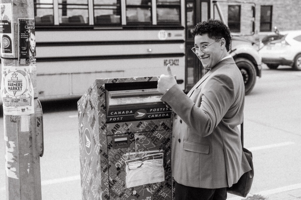 documentary-style wedding photo of officiant dropping off marriage licence at mailbox