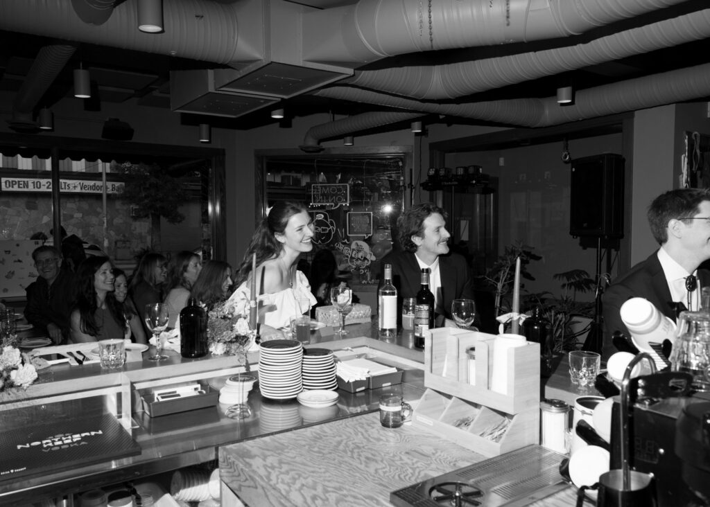 documentary-style photo at wedding reception of bride and groom reacting to speeches