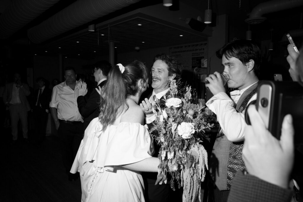 bride surprises groom with haircut on wedding day. Candid documentary-style wedding photo